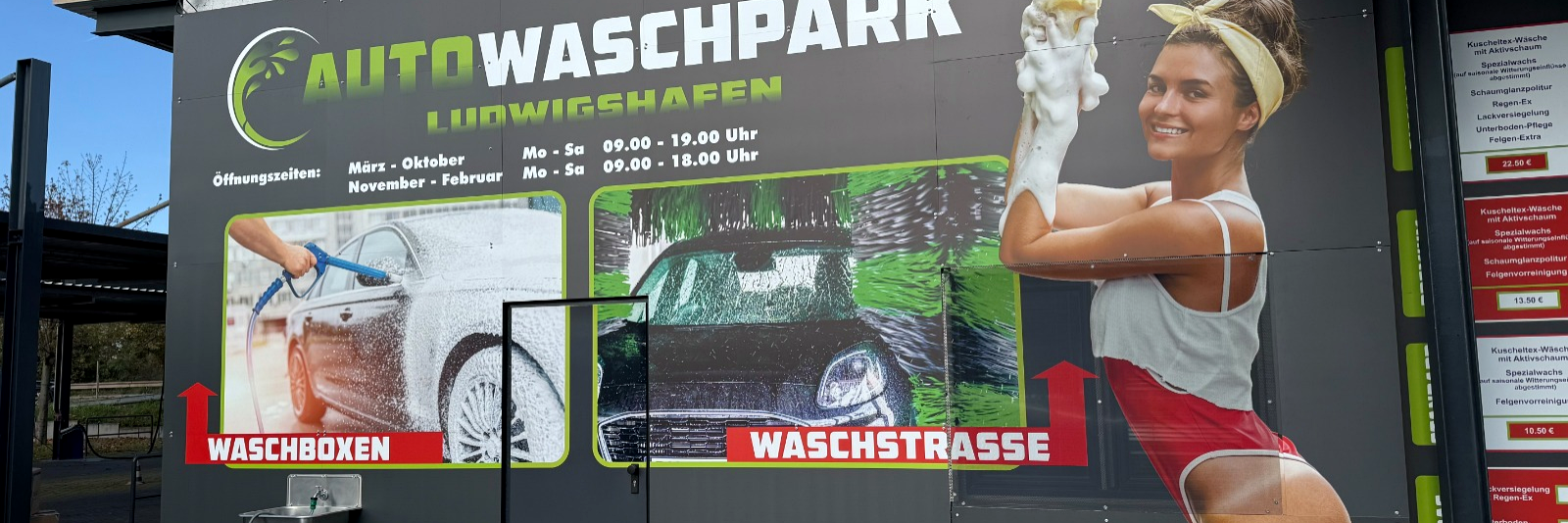 Große Werbetafel eines Autowaschparks in Ludwigshafen mit Waschmotiven und einer Frau mit Schaumhandschuh.