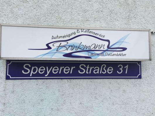 Firmenschild von Brinkmann über einem Straßenschild mit der Aufschrift Speyerer Straße 31
