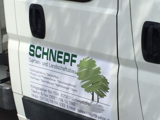 Seitenansicht eines weißen Firmenwagens mit dem Logo von Schnepf Garten und Landschaftsbau.