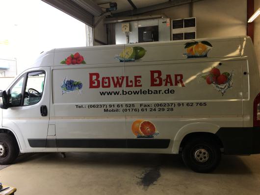 Weißer Lieferwagen mit Bowle Bar Werbung und Fruchtmotiven in einer Halle