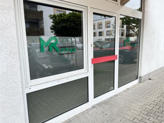 Glasfront mit Eingangstür und Firmenlogo eines Reinigungsunternehmens