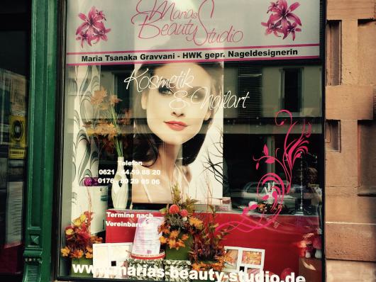 Schaufenster eines Kosmetik- und Nagelstudios mit großem Frauenporträt und pinker Beschriftung