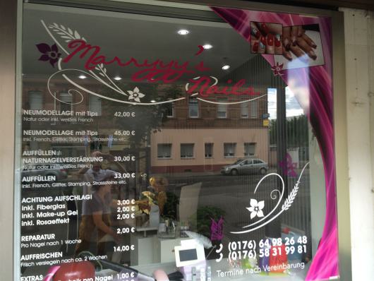 Schaufenster eines Nagelstudios mit Preisliste und auffälliger pinker Gestaltung.