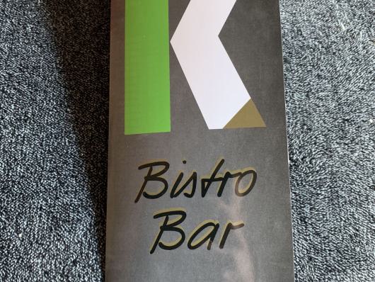 Schwarze Produktverpackung mit der Aufschrift Bärto Bar auf grauem Stoff.