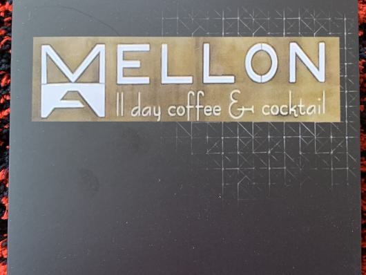 Schwarze Karte mit dem Logo MellON und der Aufschrift all day coffee & cocktail