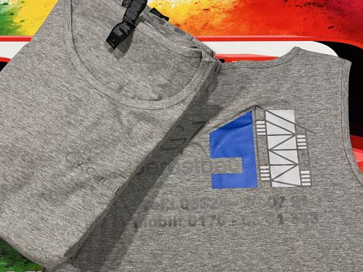 Zwei graue T-Shirts mit aufgedrucktem Motiv liegen auf einer bunten Unterlage.