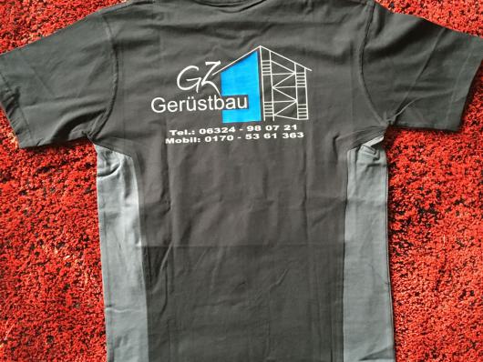 Schwarzes Sportshirt mit Gerüstbau-Aufdruck liegt auf rotem Teppich.