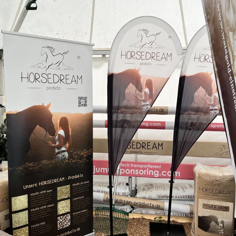 Messestand von Horsedream Products mit Bannern, Fahnen und ausgestellten Einstreuprodukten.